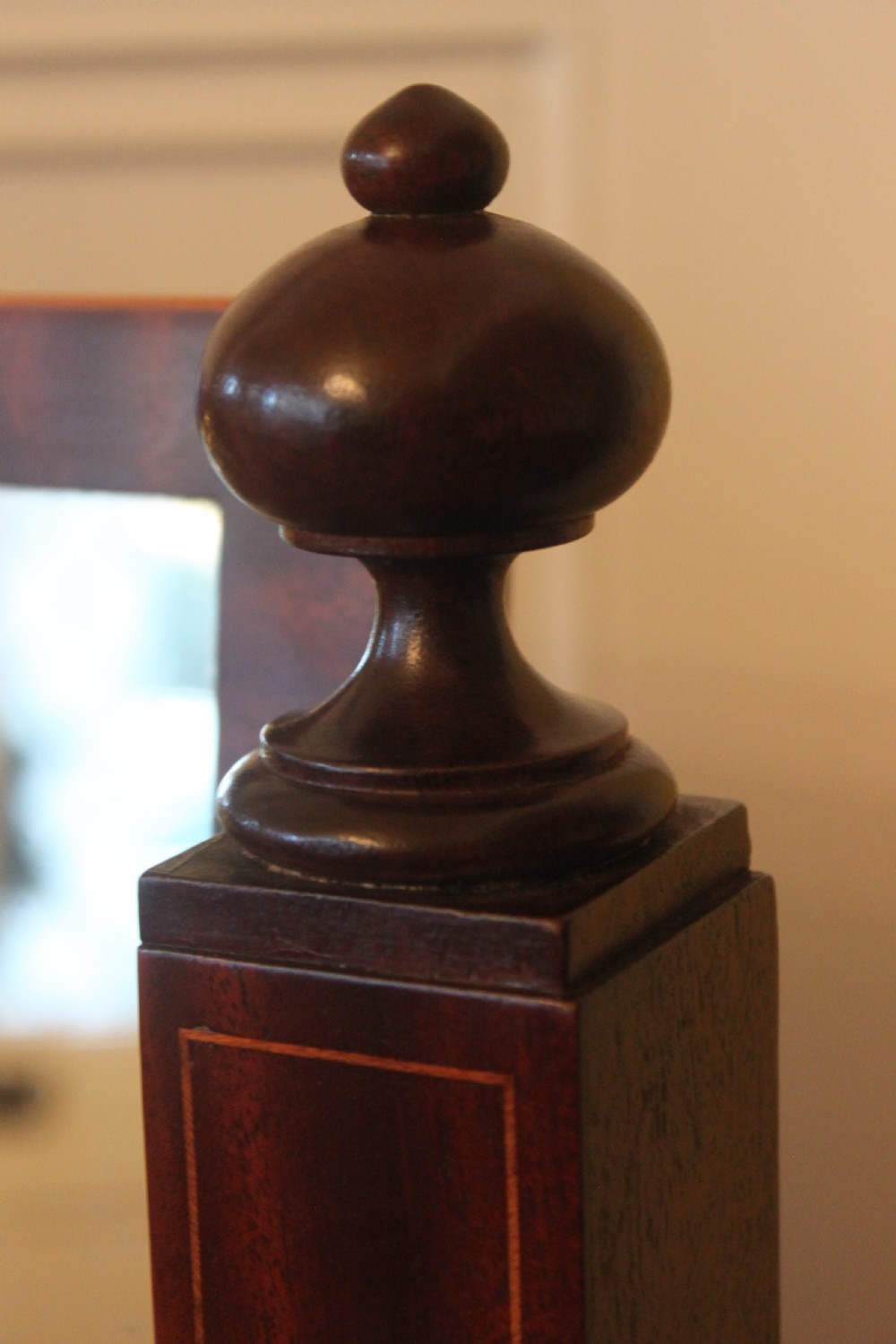 A full-length Sheraton style mahogany cheval dressing mirror with turned finials, splayed legs, brass castors, and a tilting frame. View VII