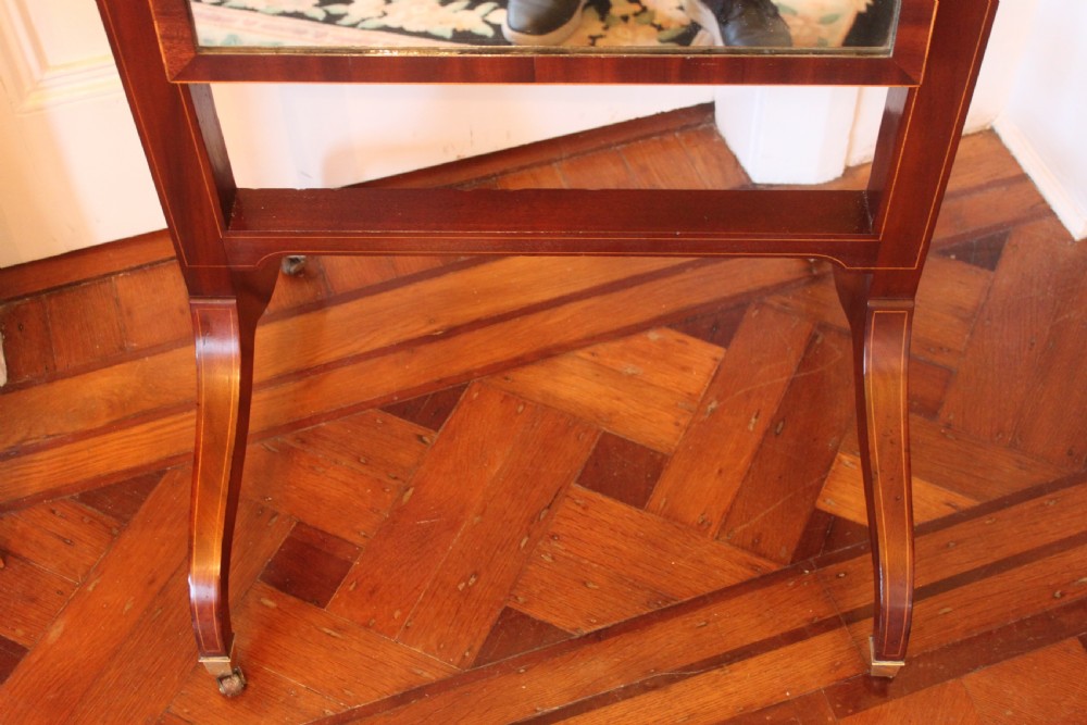 A full-length Sheraton style mahogany cheval dressing mirror with turned finials, splayed legs, brass castors, and a tilting frame. View IX