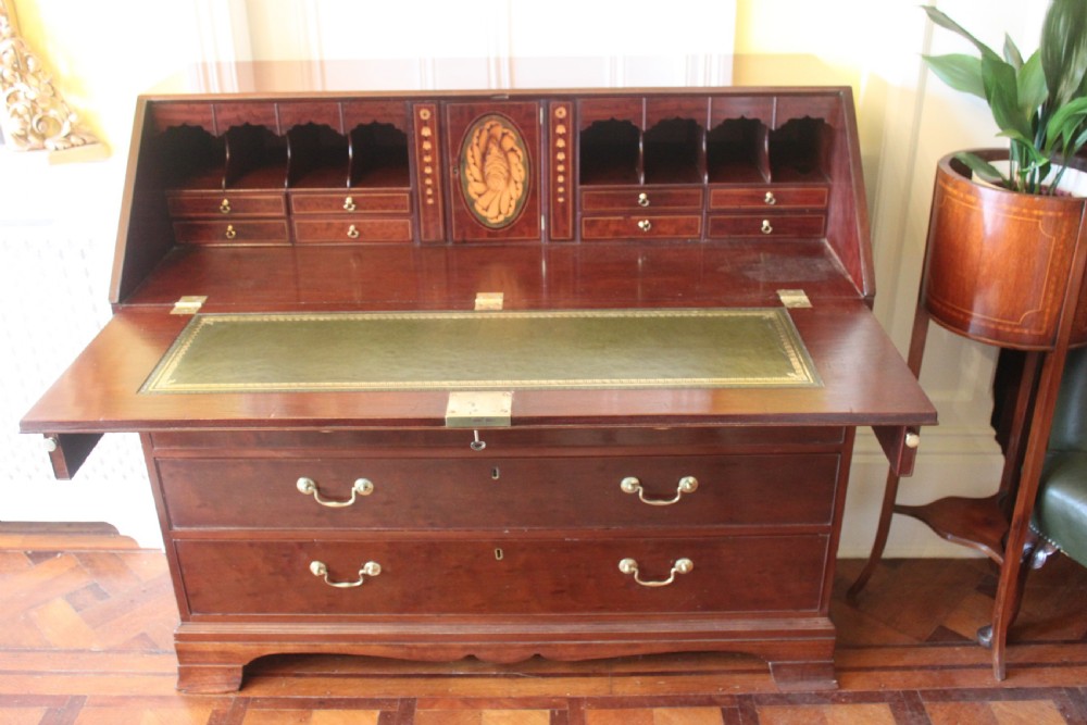An 18th-century George III mahogany slant-front bureau featuring brass swan-neck handles and inlaid stringing over four graduated drawers. View II