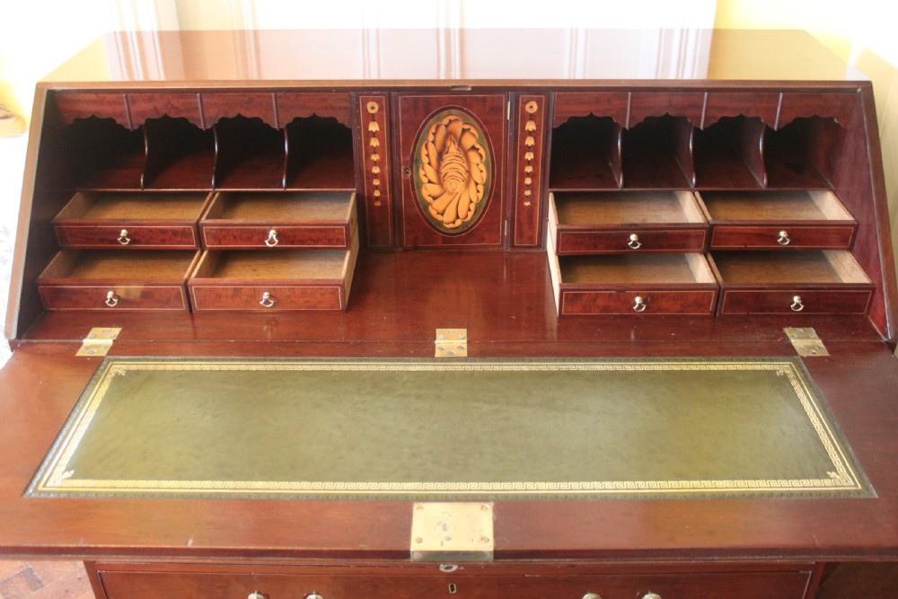 An 18th-century George III mahogany slant-front bureau featuring brass swan-neck handles and inlaid stringing over four graduated drawers. View V