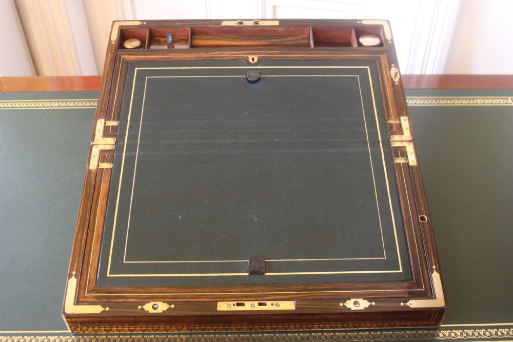 A rectangular Victorian burr walnut writing slope box featuring swirl veneer patterns, brass stringing inlay, a central engraved brass plaque, and a front keyhole escutcheon. View VII