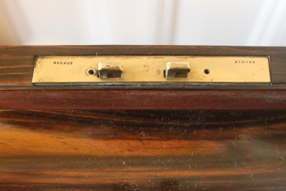 A rectangular Victorian burr walnut writing slope box featuring swirl veneer patterns, brass stringing inlay, a central engraved brass plaque, and a front keyhole escutcheon. View IX