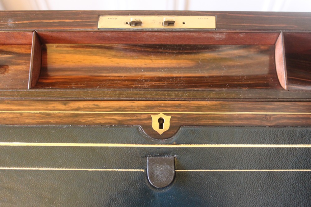 A rectangular Victorian burr walnut writing slope box featuring swirl veneer patterns, brass stringing inlay, a central engraved brass plaque, and a front keyhole escutcheon. View X