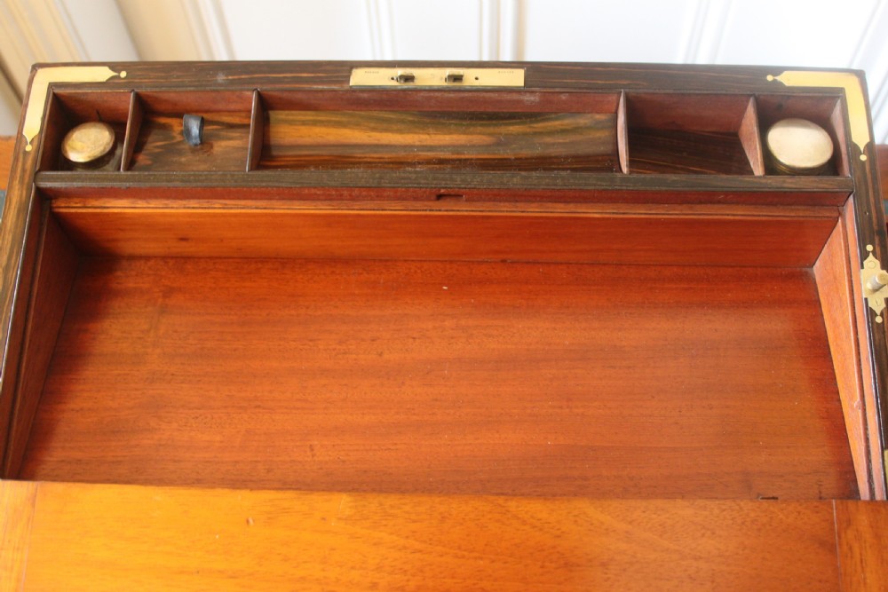 A rectangular Victorian burr walnut writing slope box featuring swirl veneer patterns, brass stringing inlay, a central engraved brass plaque, and a front keyhole escutcheon. View XII