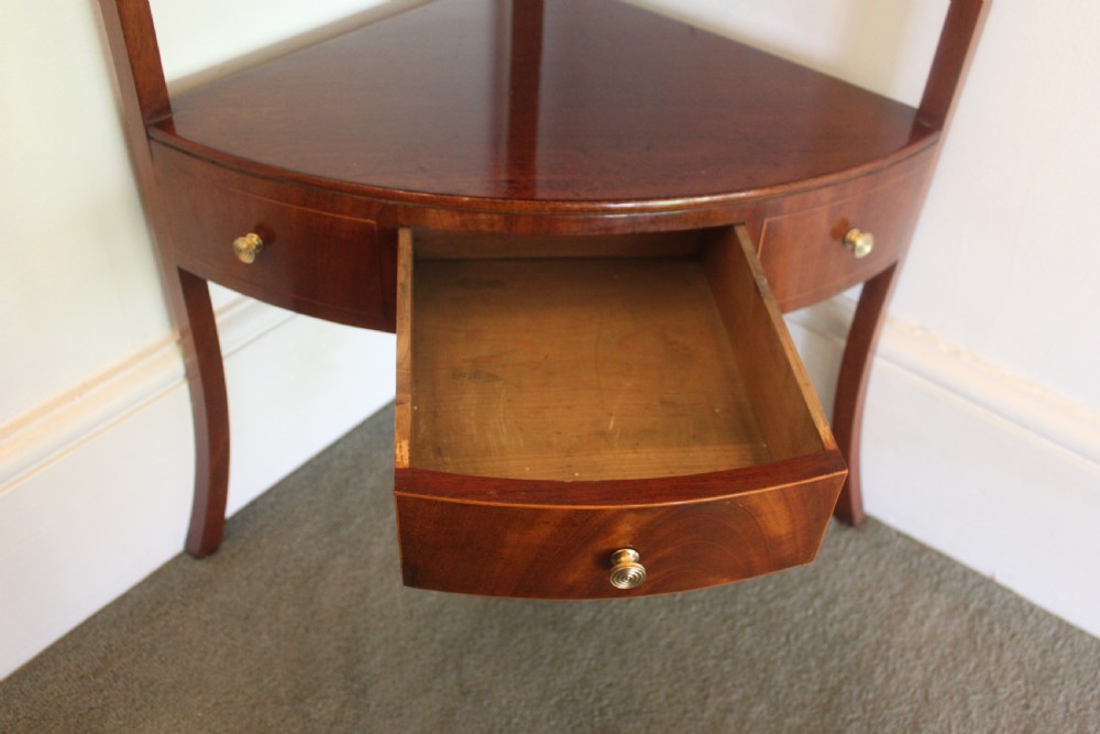 A Georgian mahogany corner washstand featuring an upper arched splashback, a central tier with a drawer, brass knobs, and curved splayed legs. View VI
