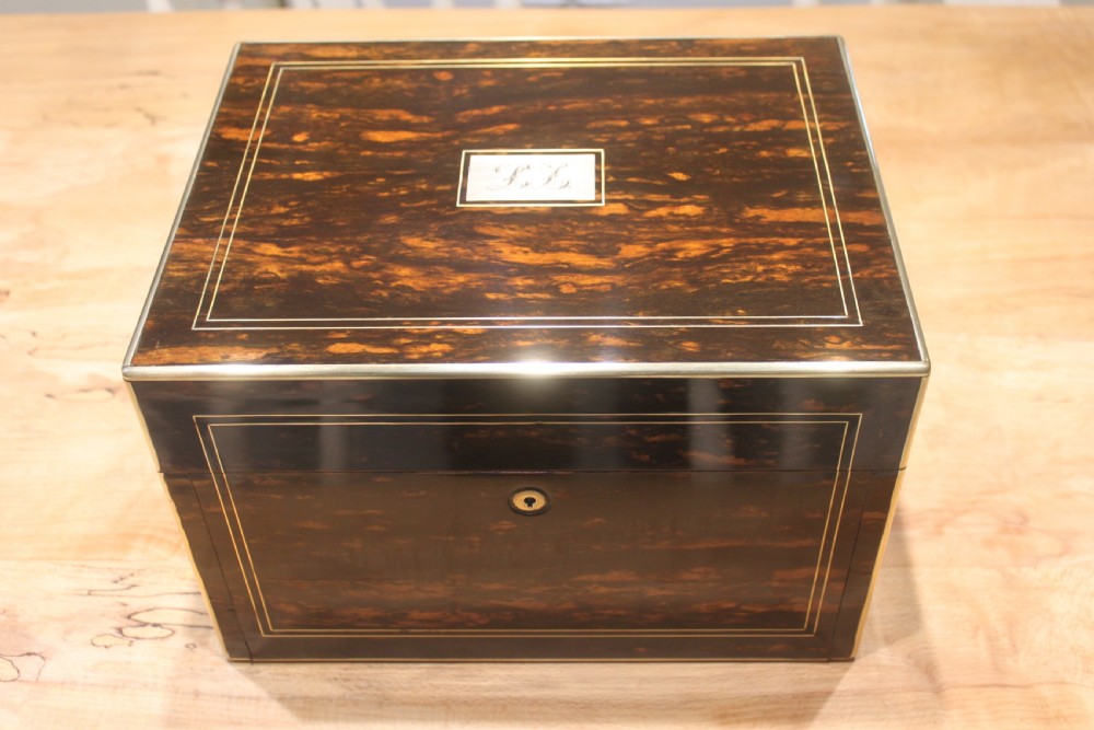 A rectangular Victorian coromandel wood dressing box with fine brass line inlay and a central monogram cartouche on the lid.