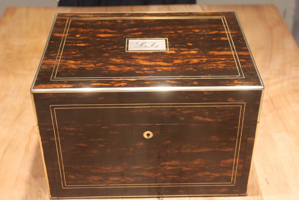 A rectangular Victorian coromandel wood dressing box with fine brass line inlay and a central monogram cartouche on the lid. View II