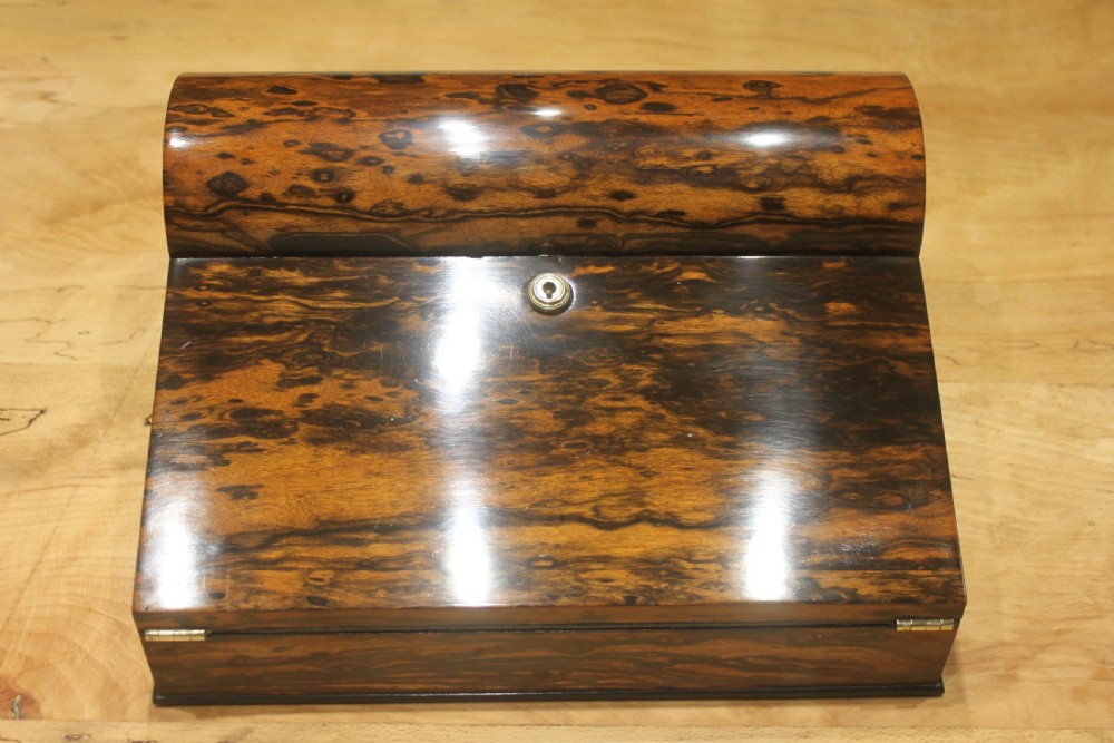 A Victorian coromandel wood writing slope featuring distinct dark and golden brown grain patterns, a rounded top section, and a central brass keyhole.