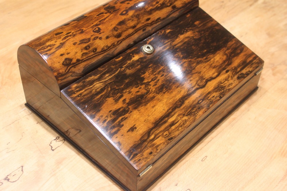 A Victorian coromandel wood writing slope featuring distinct dark and golden brown grain patterns, a rounded top section, and a central brass keyhole. View II