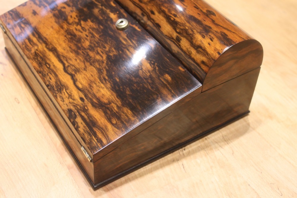 A Victorian coromandel wood writing slope featuring distinct dark and golden brown grain patterns, a rounded top section, and a central brass keyhole. View III