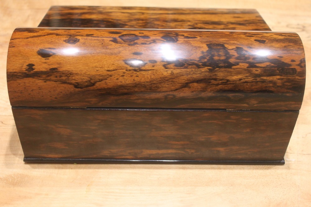 A Victorian coromandel wood writing slope featuring distinct dark and golden brown grain patterns, a rounded top section, and a central brass keyhole. View V