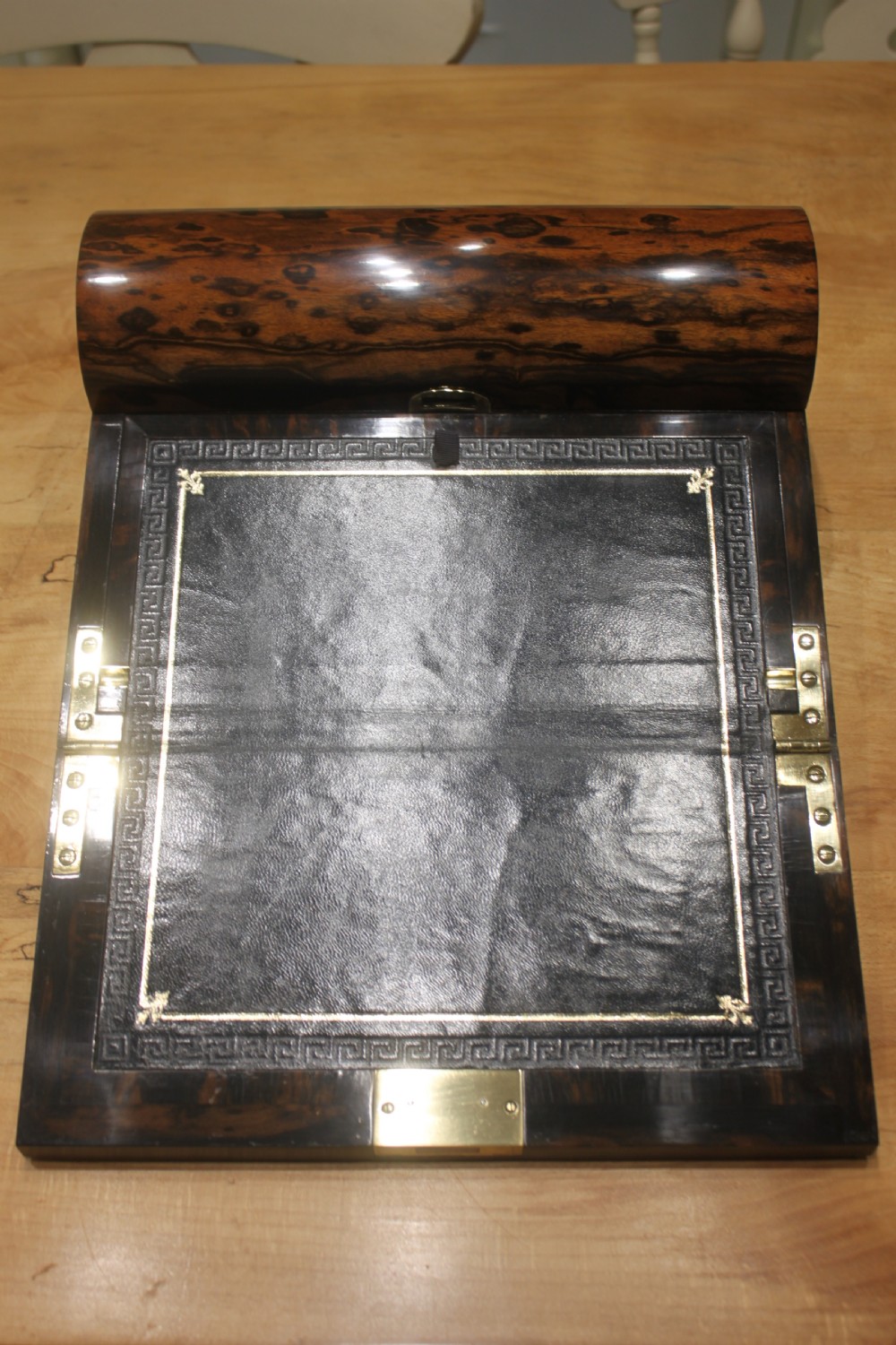 A Victorian coromandel wood writing slope featuring distinct dark and golden brown grain patterns, a rounded top section, and a central brass keyhole. View VI