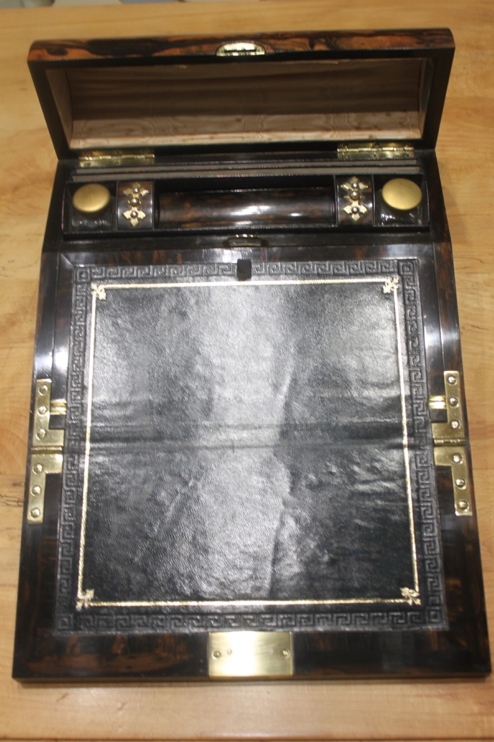 A Victorian coromandel wood writing slope featuring distinct dark and golden brown grain patterns, a rounded top section, and a central brass keyhole. View VIII