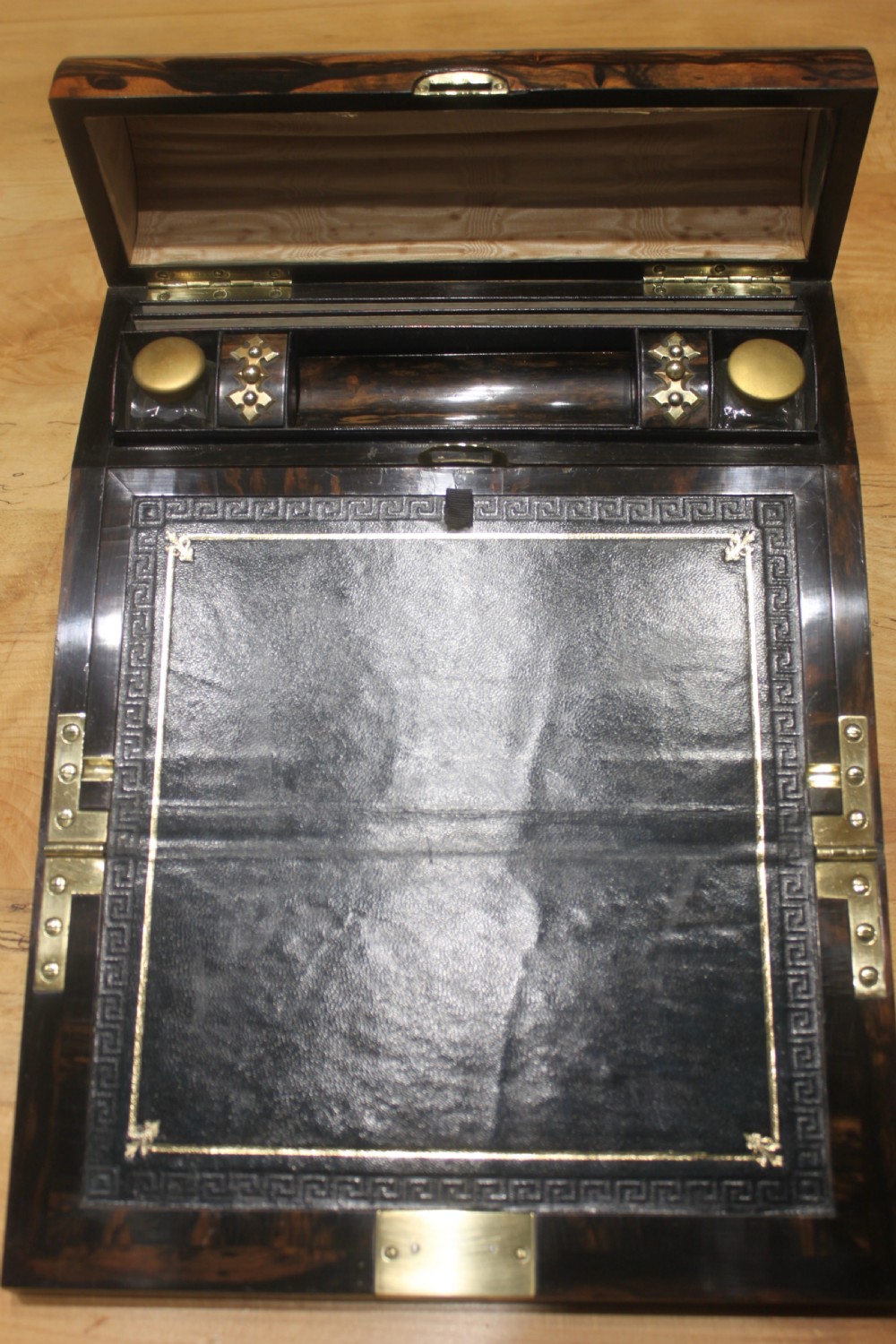 A Victorian coromandel wood writing slope featuring distinct dark and golden brown grain patterns, a rounded top section, and a central brass keyhole. View IX