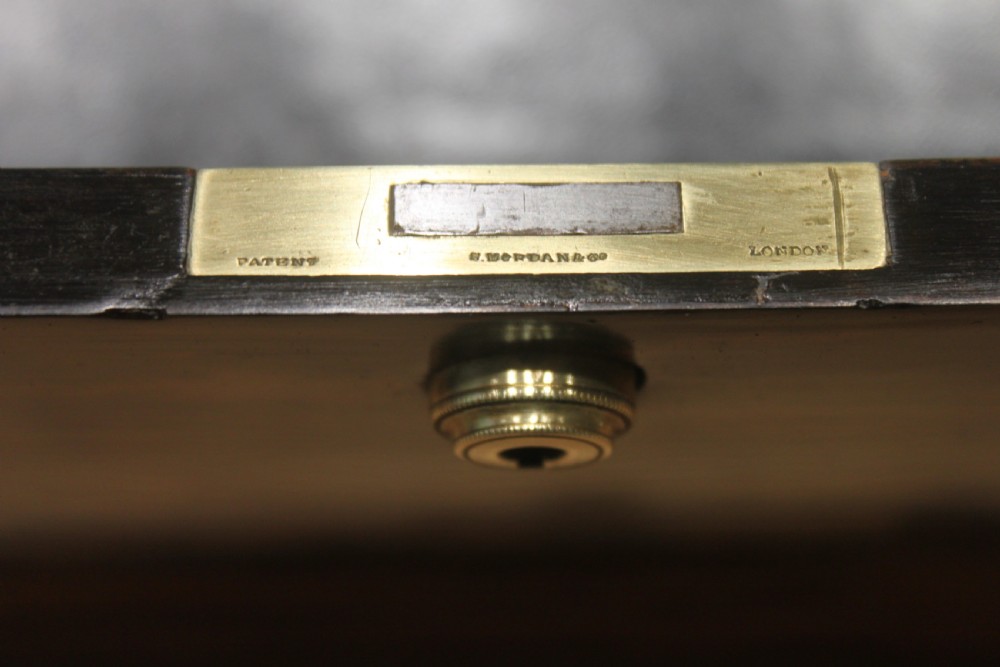 A Victorian coromandel wood writing slope featuring distinct dark and golden brown grain patterns, a rounded top section, and a central brass keyhole. View XIV