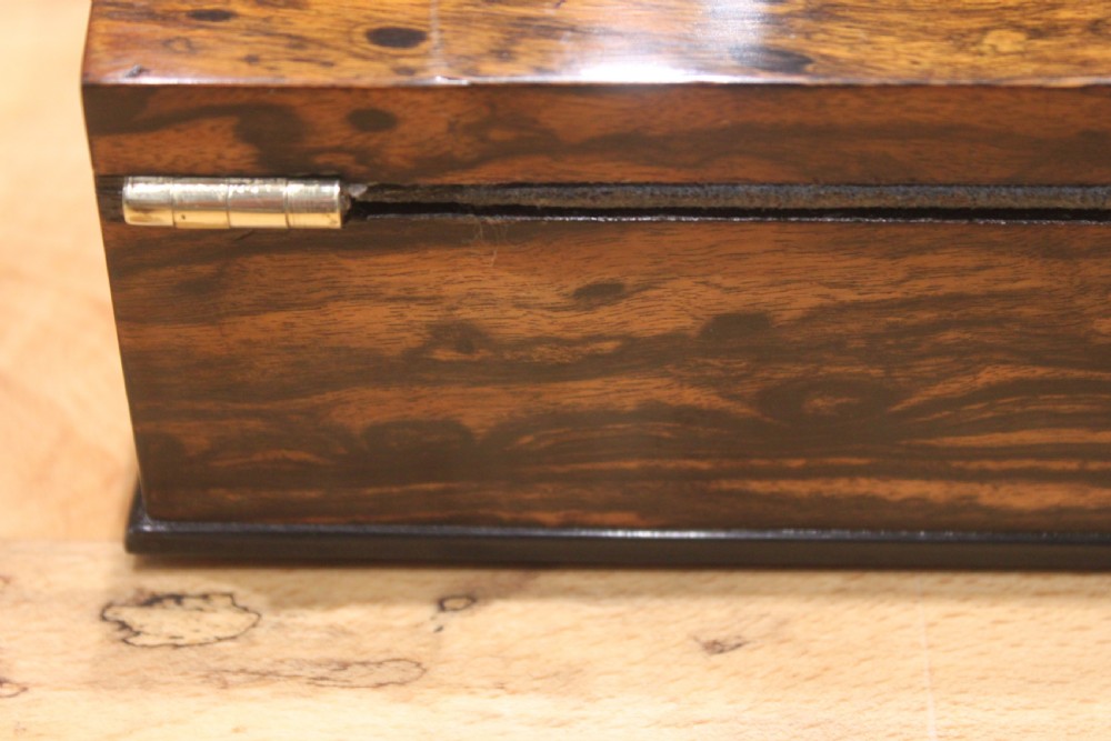 A Victorian coromandel wood writing slope featuring distinct dark and golden brown grain patterns, a rounded top section, and a central brass keyhole. View XV