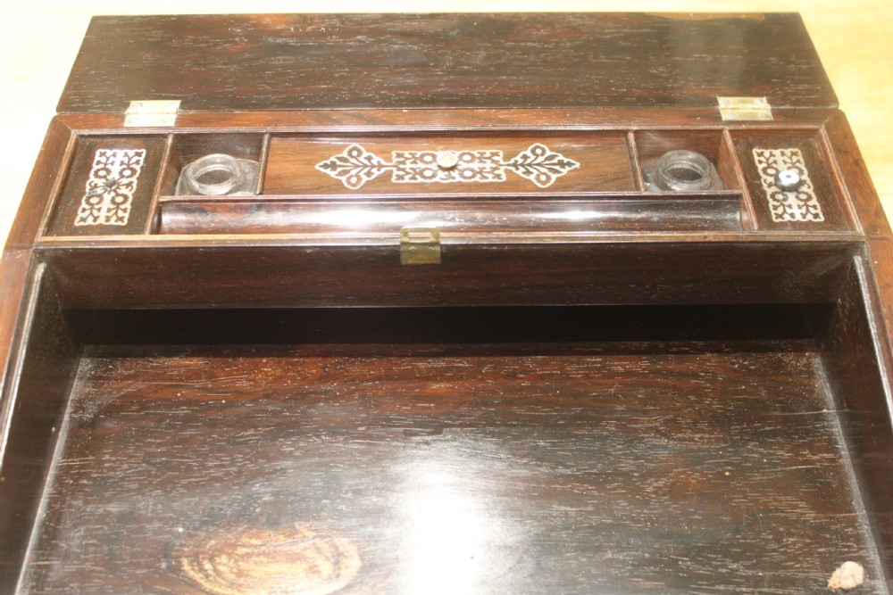 A dark rosewood rectangular writing slope box decorated with intricate mother-of-pearl foliate floral inlay and a central keyhole escutcheon. View IX