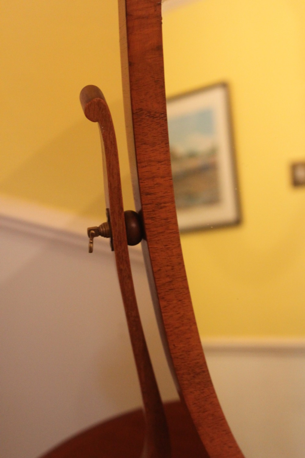 An Edwardian Hepplewhite style mahogany toilet mirror featuring a shield-shaped frame supported by two curved upright legs. View III