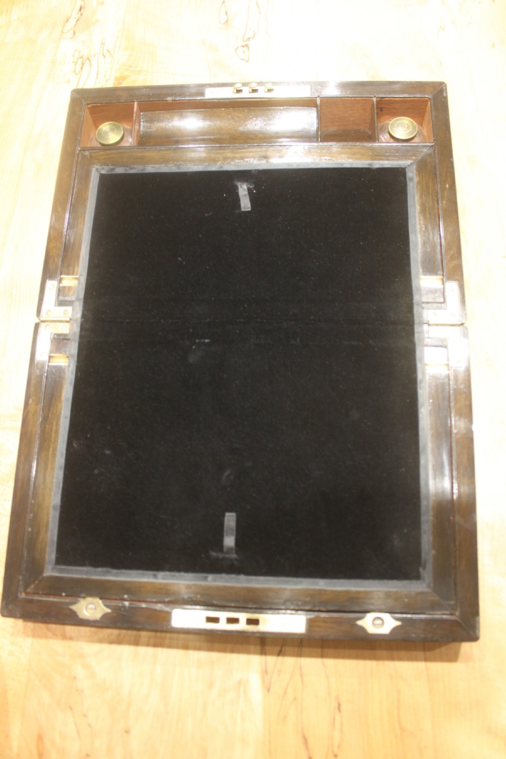 A rectangular Victorian burr walnut writing slope featuring a brass cartouche on top and a brass escutcheon with key on the front. View VII