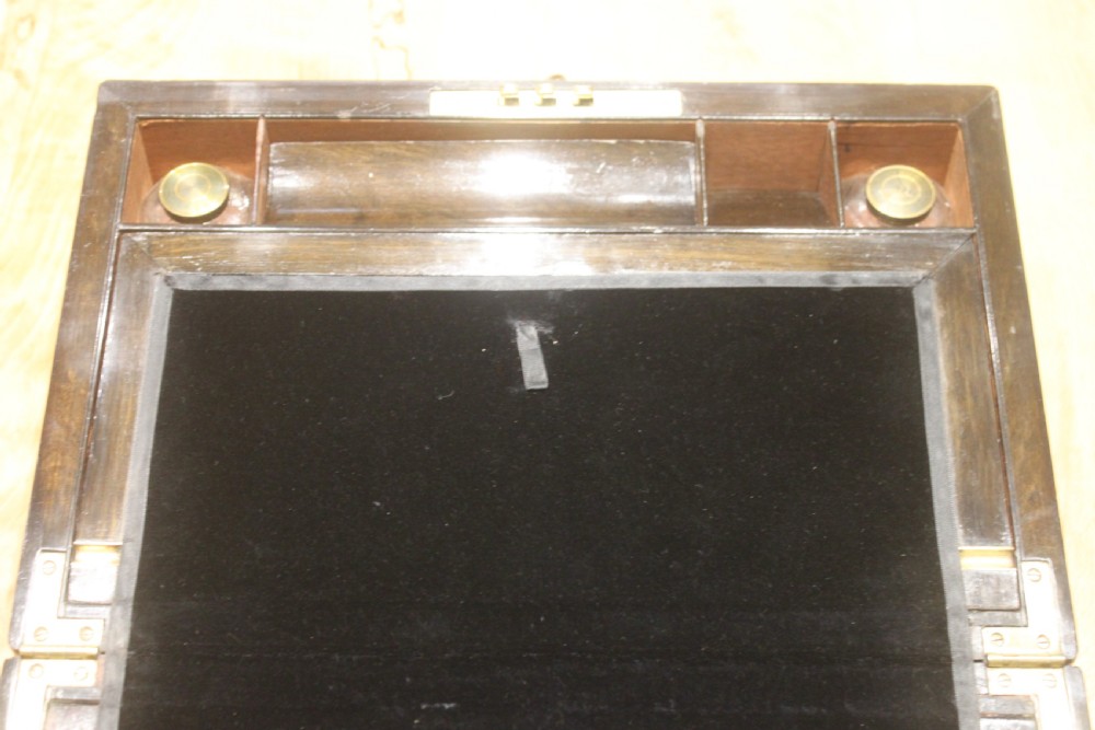 A rectangular Victorian burr walnut writing slope featuring a brass cartouche on top and a brass escutcheon with key on the front. View IX