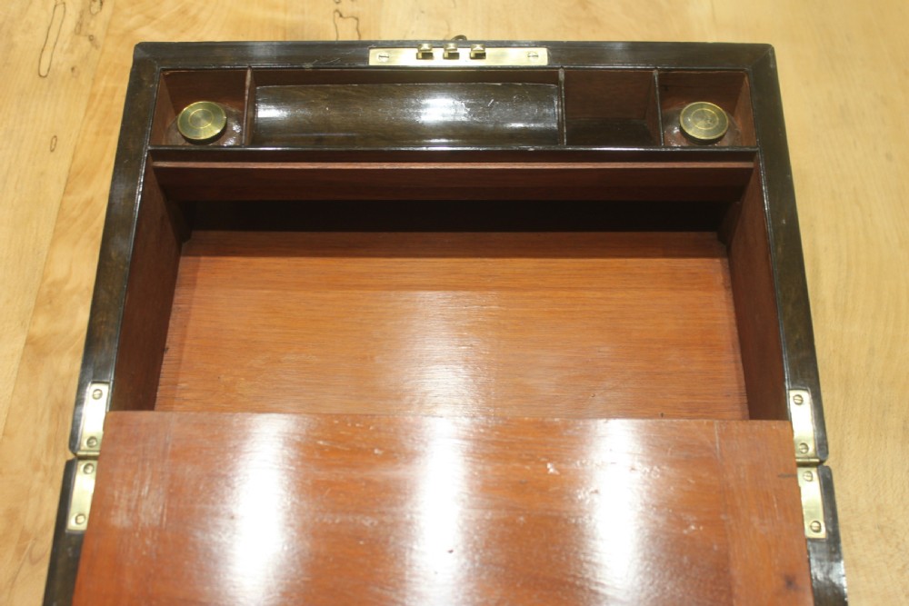 A rectangular Victorian burr walnut writing slope featuring a brass cartouche on top and a brass escutcheon with key on the front. View X