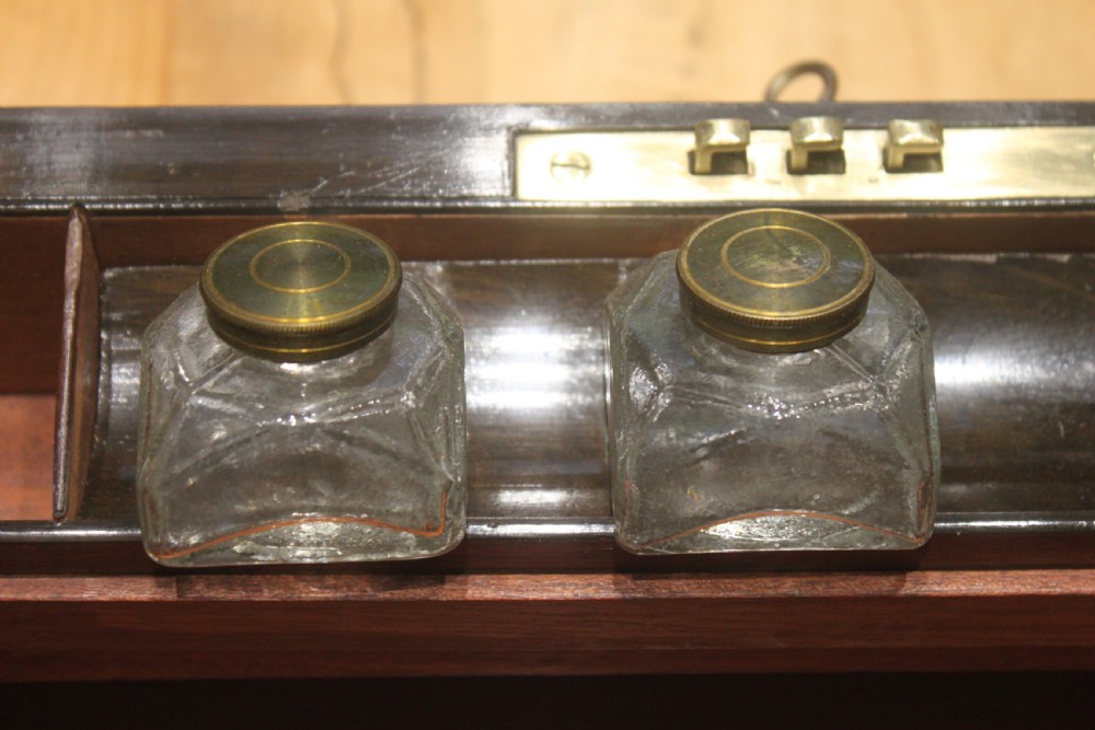 A rectangular Victorian burr walnut writing slope featuring a brass cartouche on top and a brass escutcheon with key on the front. View XI