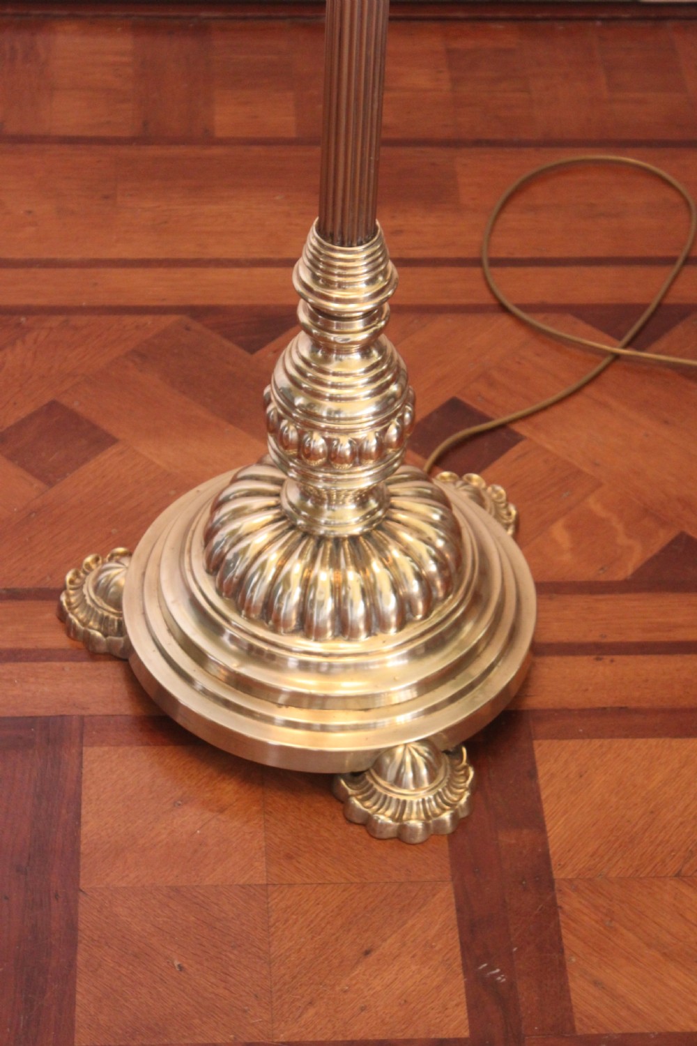 A tall Victorian brass telescopic standard lamp featuring a reeded column, gadrooned base, and a pleated fabric lampshade. View II