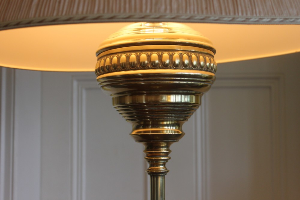 A tall Victorian brass telescopic standard lamp featuring a reeded column, gadrooned base, and a pleated fabric lampshade. View V