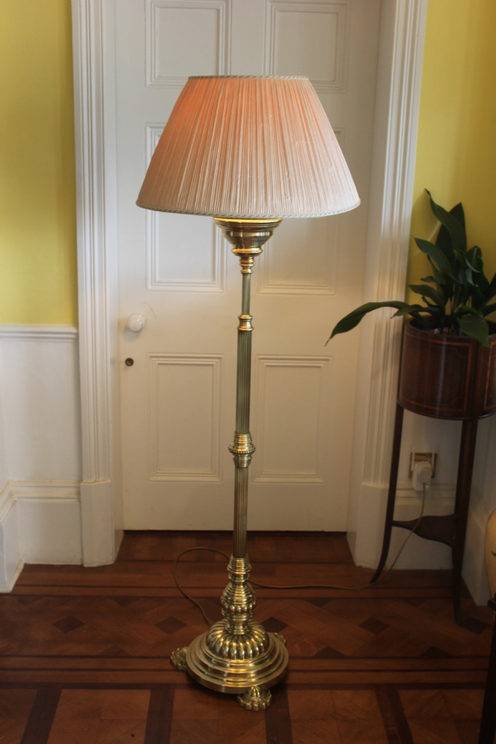 A tall Victorian brass telescopic standard lamp featuring a reeded column, gadrooned base, and a pleated fabric lampshade. View IX