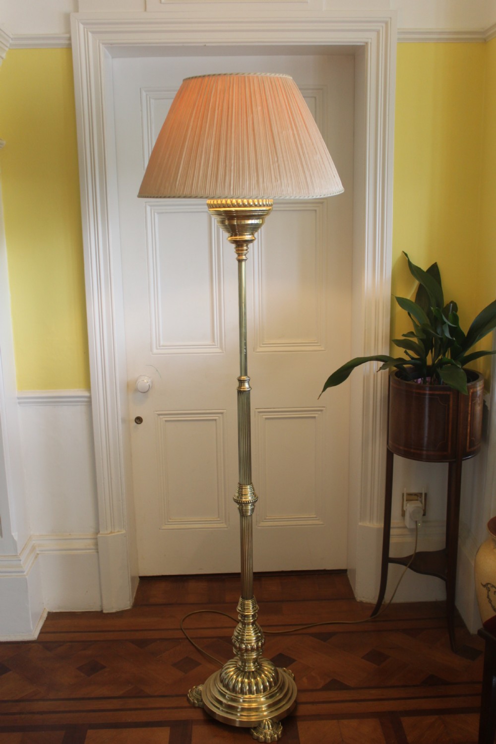 A tall Victorian brass telescopic standard lamp featuring a reeded column, gadrooned base, and a pleated fabric lampshade. View X