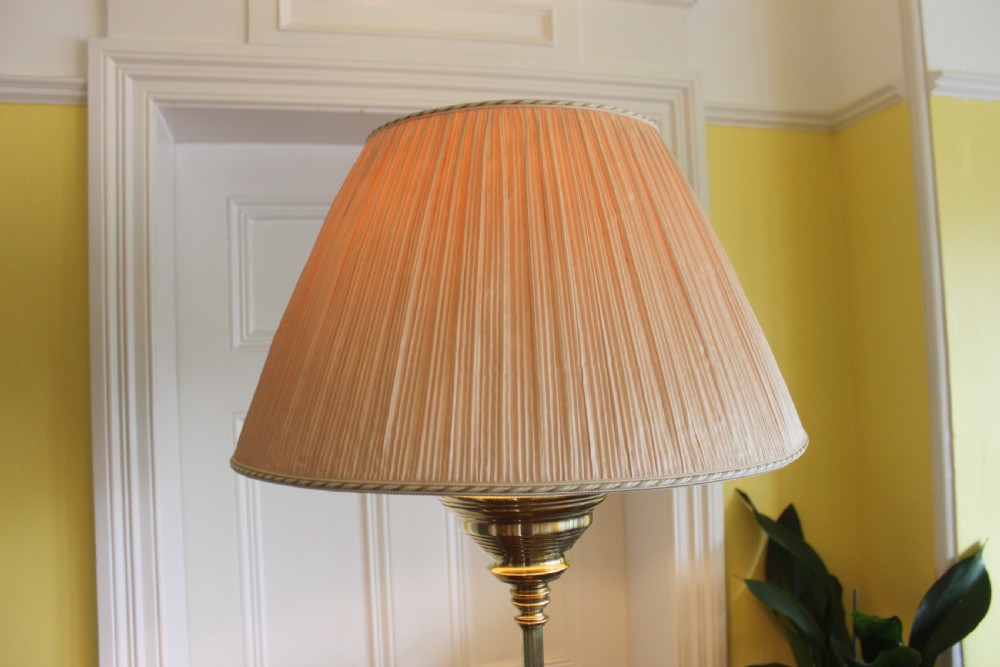 A tall Victorian brass telescopic standard lamp featuring a reeded column, gadrooned base, and a pleated fabric lampshade. View XI