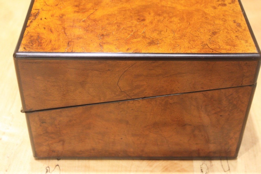 A rectangular antique burr walnut writing slope with an inlaid central cartouche and a brass circular Bramah lock on the front face. View III