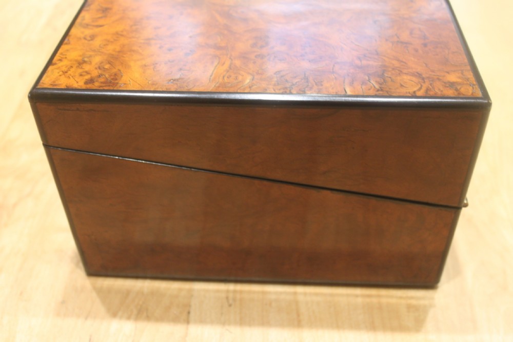 A rectangular antique burr walnut writing slope with an inlaid central cartouche and a brass circular Bramah lock on the front face. View VI