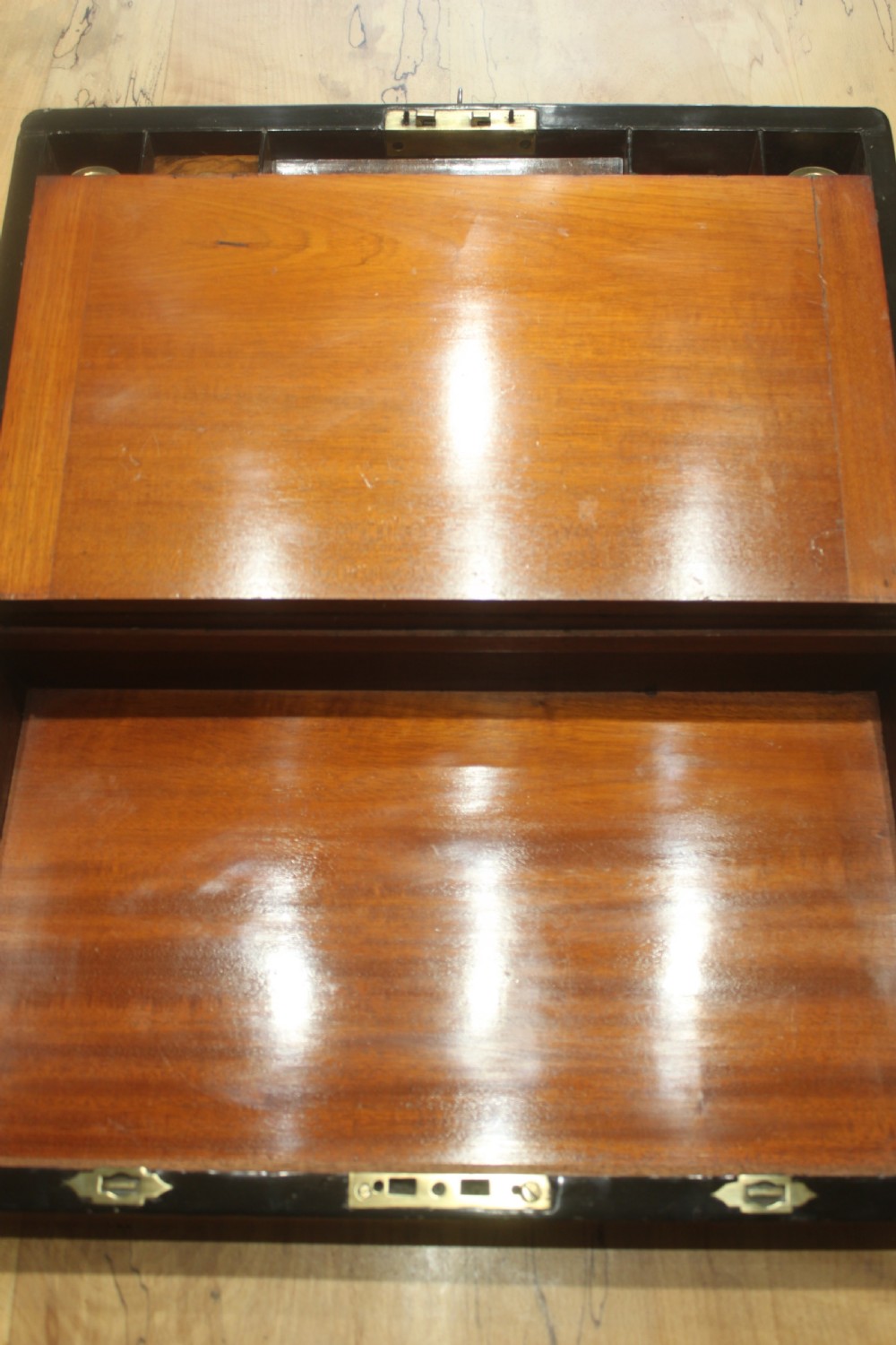 A rectangular Victorian walnut writing slope featuring brass bound corners, a central rectangular brass cartouche, and a key inserted into the front keyhole plate. View VIII