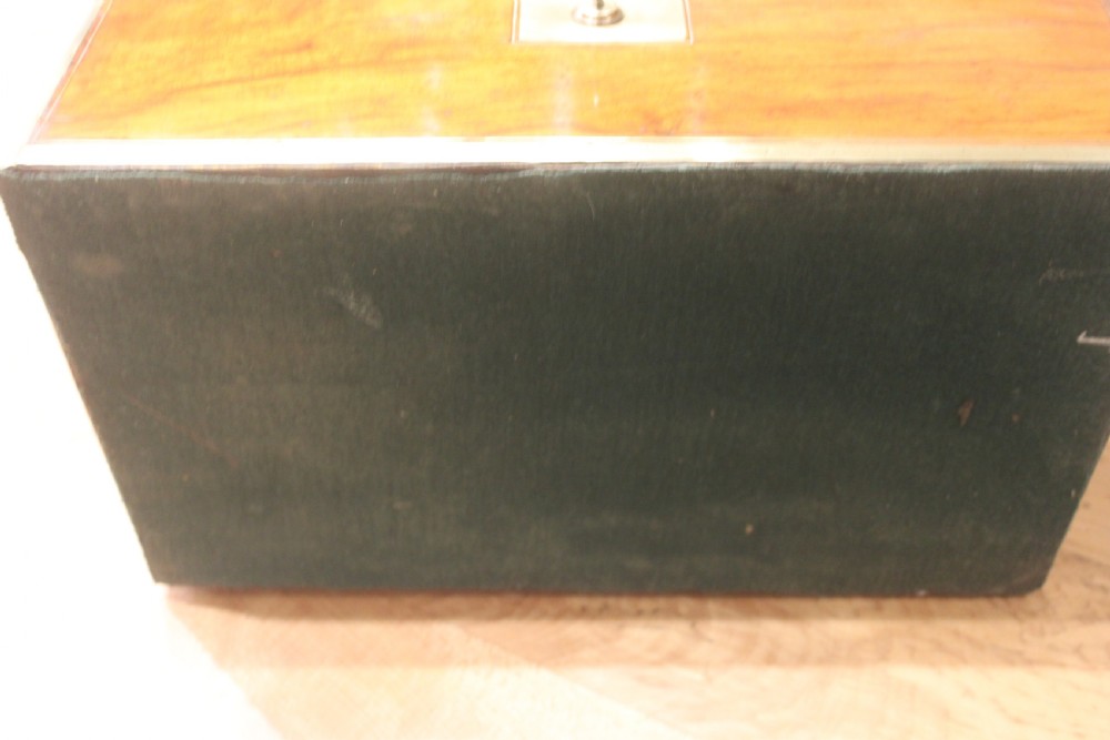 A rectangular Victorian walnut writing slope featuring brass bound corners, a central rectangular brass cartouche, and a key inserted into the front keyhole plate. View XIV
