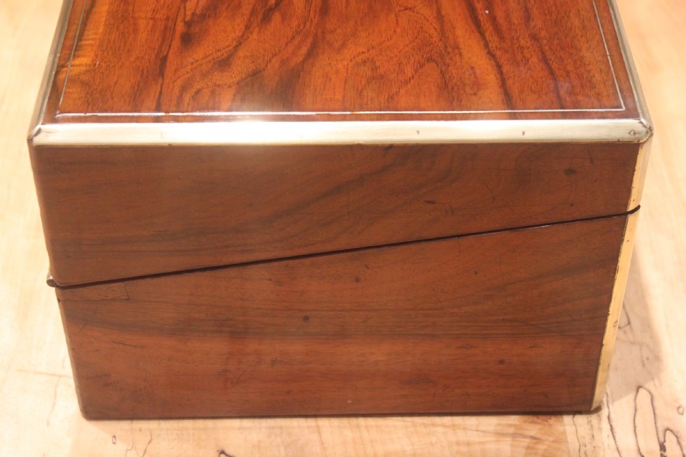 A rectangular dark walnut box featuring brass corner edging, an inlaid brass cartouche on the lid, and a brass escutcheon with a key and tassel. View II