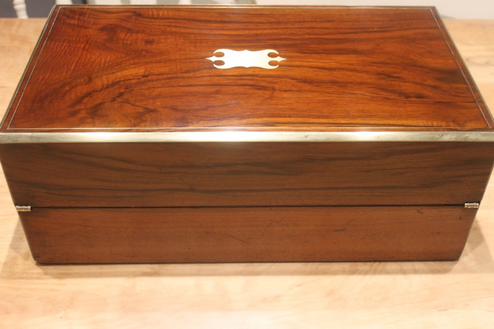 A rectangular dark walnut box featuring brass corner edging, an inlaid brass cartouche on the lid, and a brass escutcheon with a key and tassel. View III