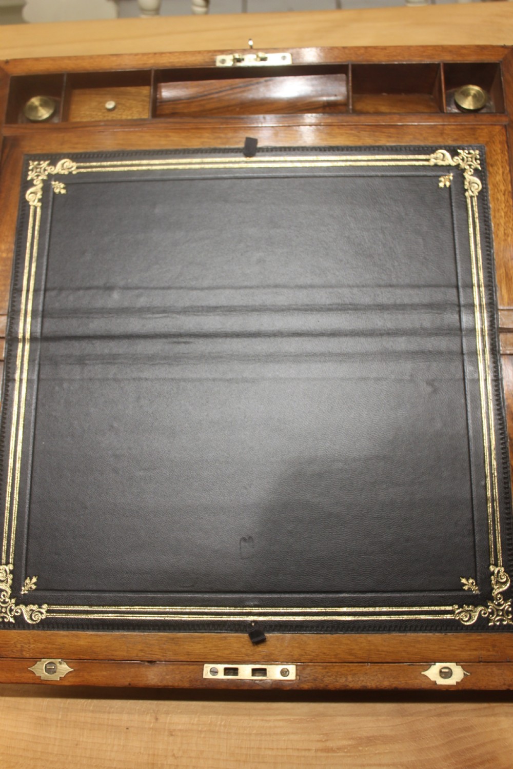 A rectangular dark walnut box featuring brass corner edging, an inlaid brass cartouche on the lid, and a brass escutcheon with a key and tassel. View VI