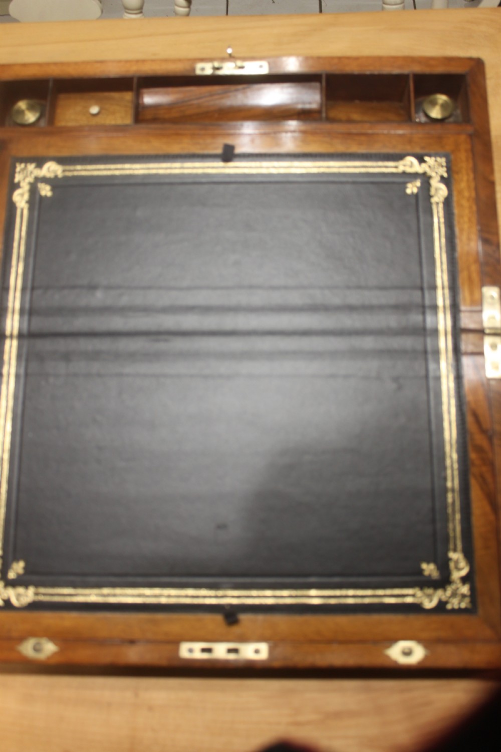 A rectangular dark walnut box featuring brass corner edging, an inlaid brass cartouche on the lid, and a brass escutcheon with a key and tassel. View VII