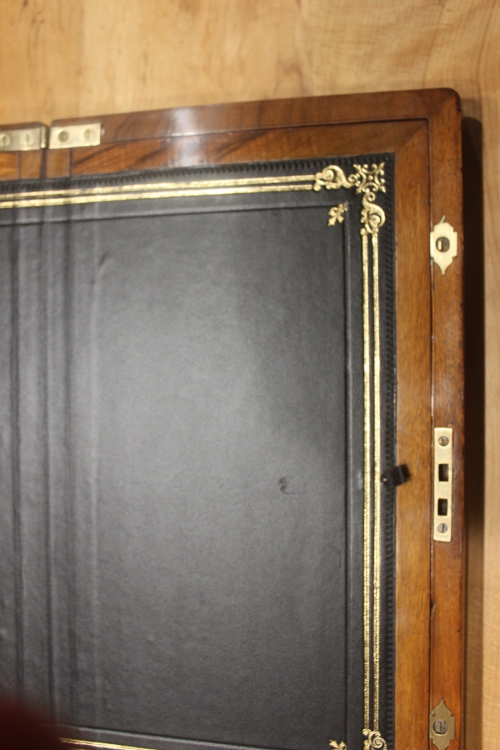 A rectangular dark walnut box featuring brass corner edging, an inlaid brass cartouche on the lid, and a brass escutcheon with a key and tassel. View VIII