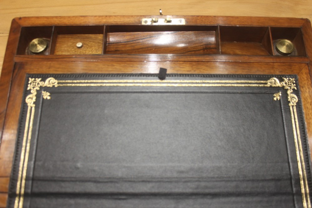 A rectangular dark walnut box featuring brass corner edging, an inlaid brass cartouche on the lid, and a brass escutcheon with a key and tassel. View X