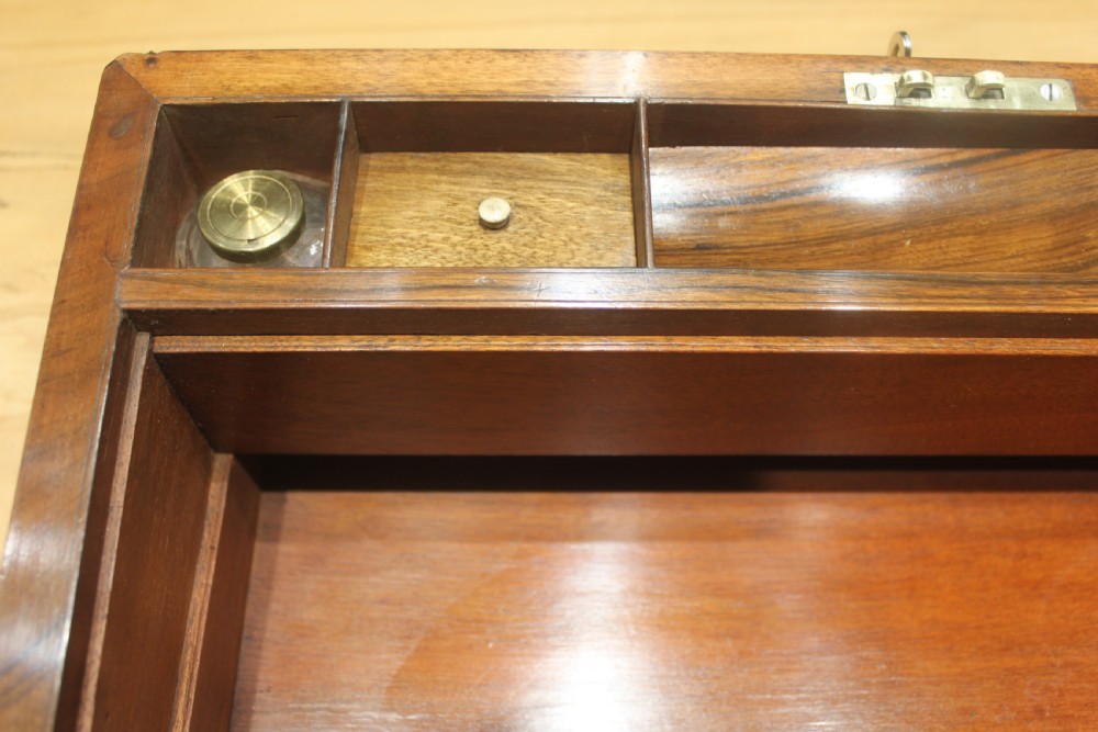 A rectangular dark walnut box featuring brass corner edging, an inlaid brass cartouche on the lid, and a brass escutcheon with a key and tassel. View XIV