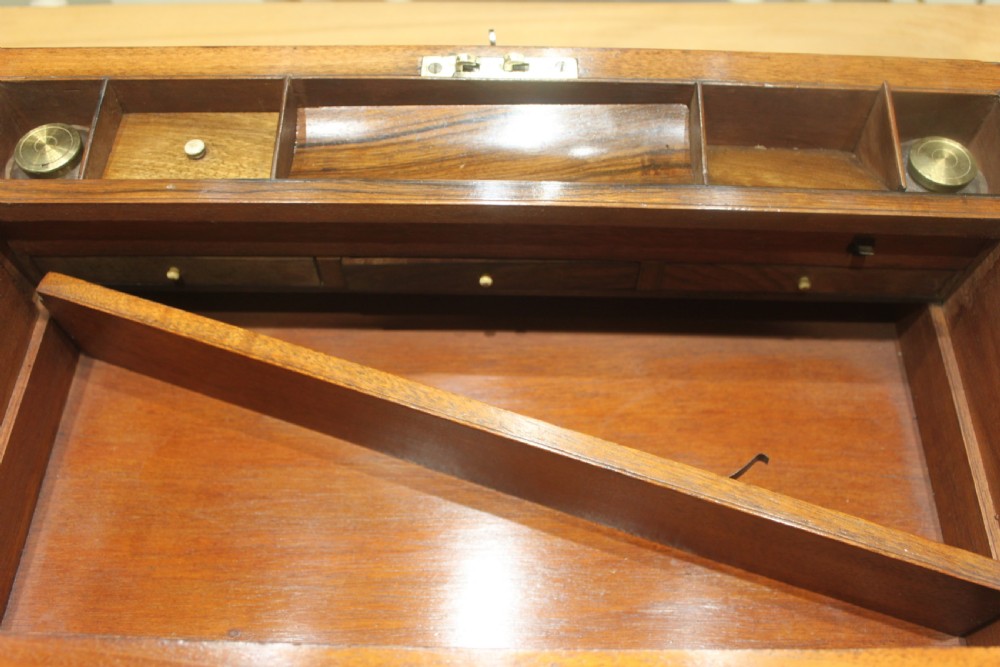 A rectangular dark walnut box featuring brass corner edging, an inlaid brass cartouche on the lid, and a brass escutcheon with a key and tassel. View XVI