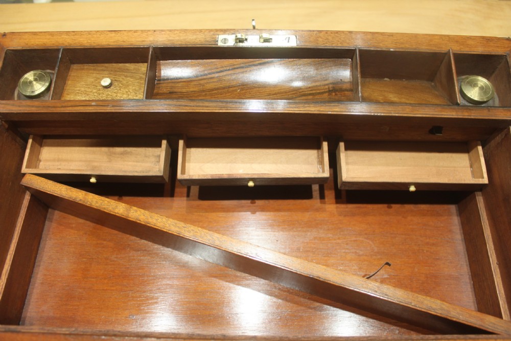 A rectangular dark walnut box featuring brass corner edging, an inlaid brass cartouche on the lid, and a brass escutcheon with a key and tassel. View XVII