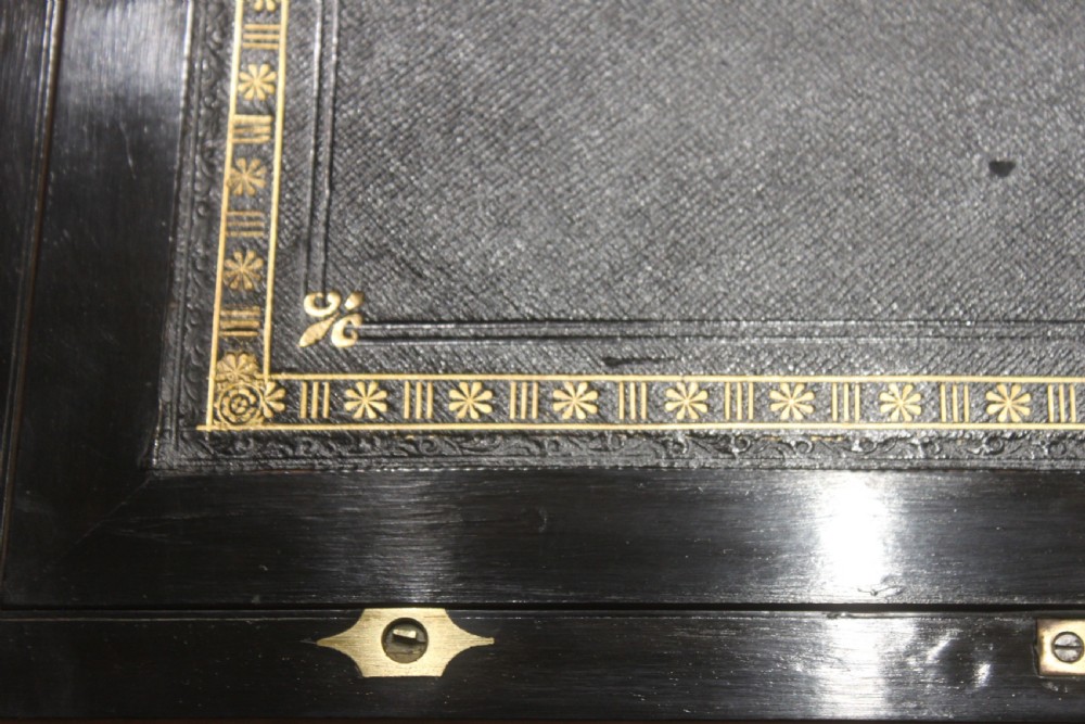 A rectangular Victorian writing slope crafted from figured walnut with brass binding, a top brass cartouche, and a brass key escutcheon with a tassel. View VIII