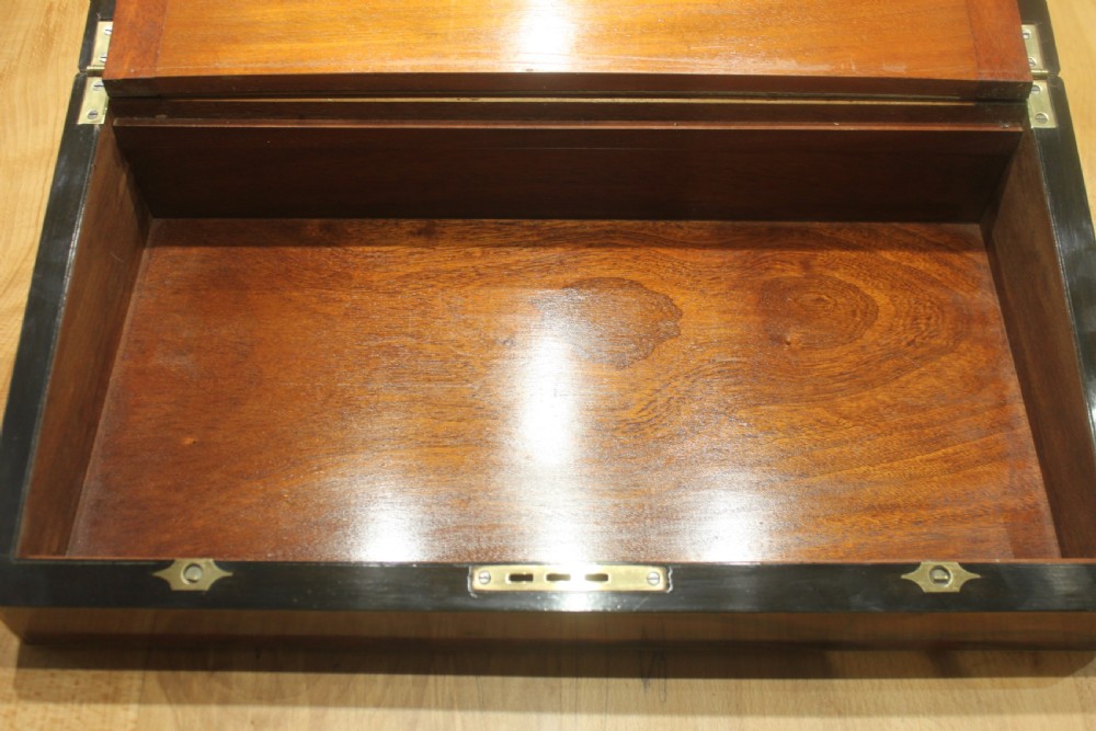 A rectangular Victorian writing slope crafted from figured walnut with brass binding, a top brass cartouche, and a brass key escutcheon with a tassel. View IX