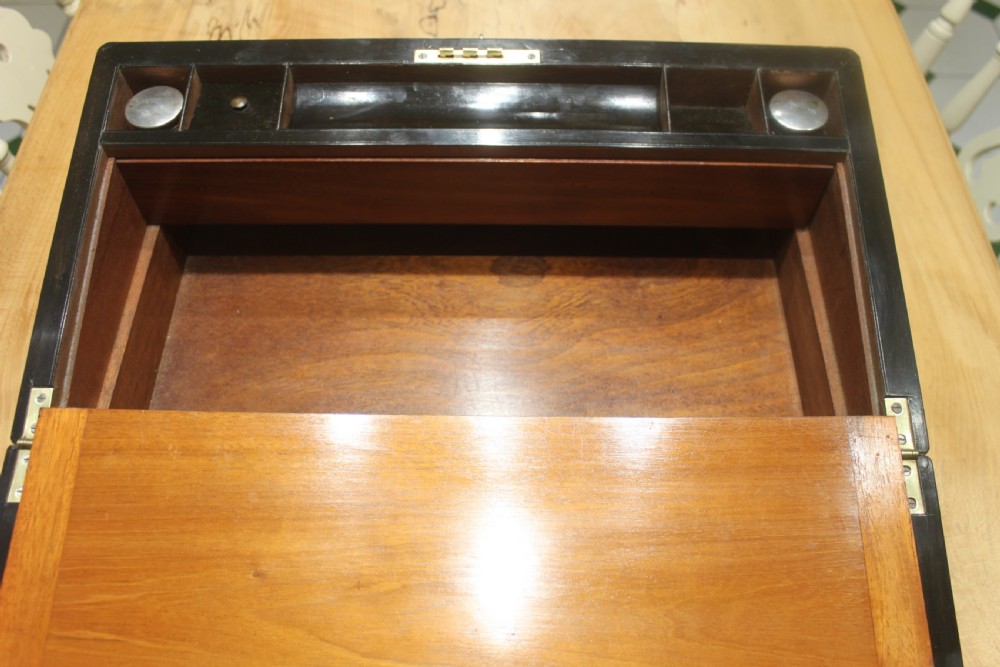 A rectangular Victorian writing slope crafted from figured walnut with brass binding, a top brass cartouche, and a brass key escutcheon with a tassel. View XI