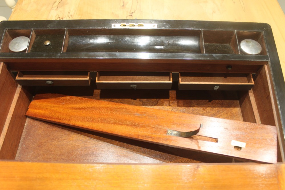 A rectangular Victorian writing slope crafted from figured walnut with brass binding, a top brass cartouche, and a brass key escutcheon with a tassel. View XIV