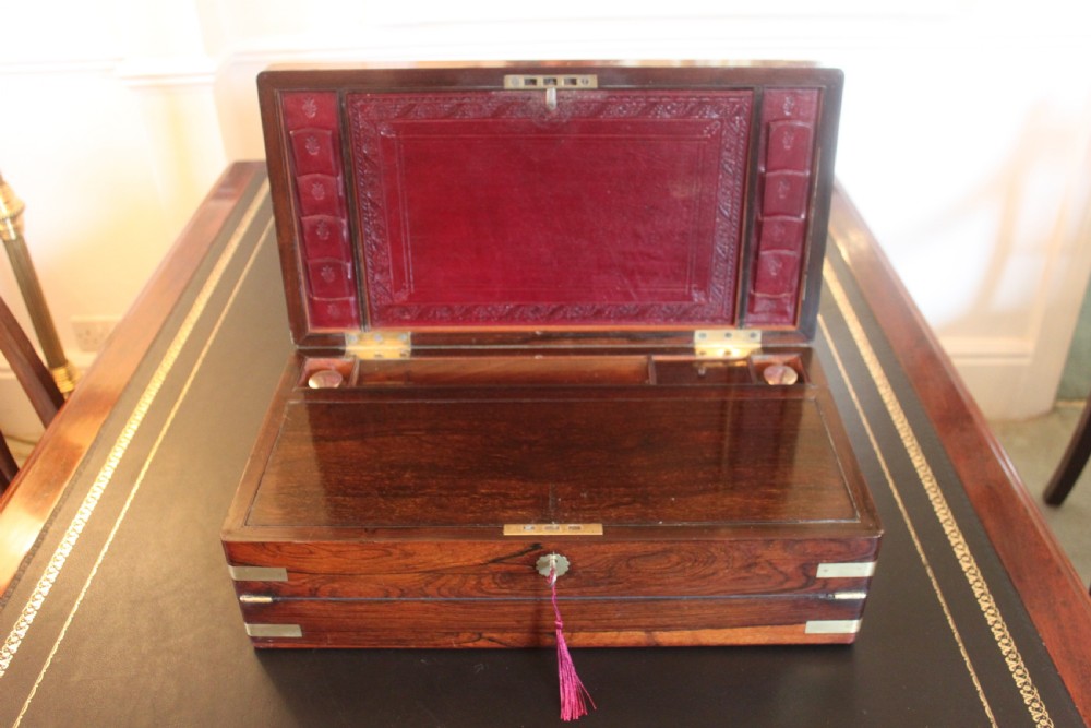 A rectangular dark rosewood writing slope box with brass corner mounts, brass cartouche inlay, and a central brass keyhole with a tassel. View VI