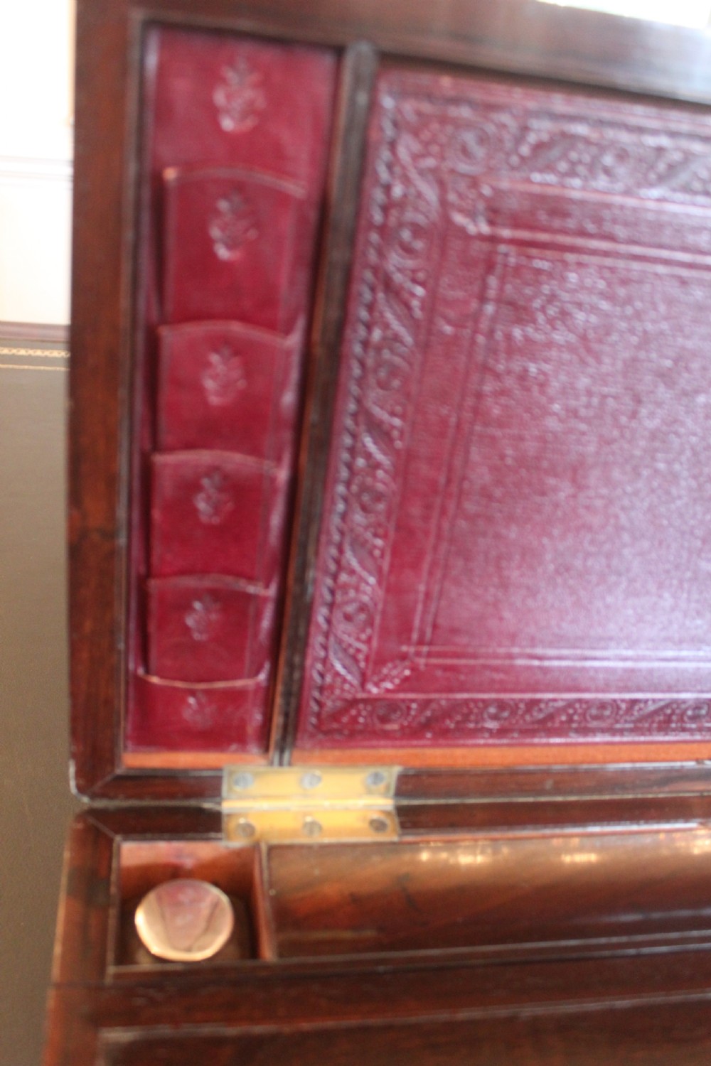 A rectangular dark rosewood writing slope box with brass corner mounts, brass cartouche inlay, and a central brass keyhole with a tassel. View VII